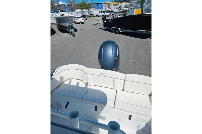 Slide: The Image of 2023 Sea Hunt Ultra 229 boat with seating and outboard motor in a parking area. - 9