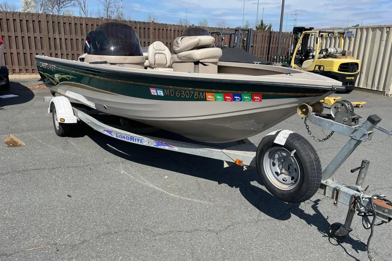 Slide: The Image of 2003 Crestliner 1850 Fish Hawk SC boat on trailer in parking lot. - 2