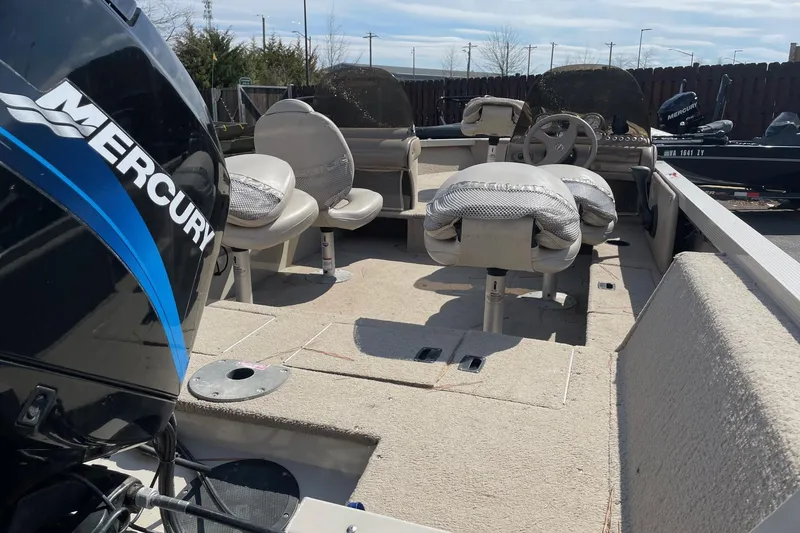 Slide: The Image of 2003 Crestliner 1850 Fish Hawk SC boat interior with Mercury engine, featuring seating and steering wheel. - 7