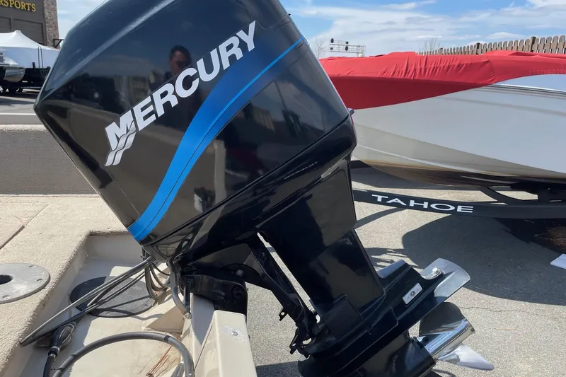Slide: The Image of Mercury outboard motor on 2003 Crestliner 1850 Fish Hawk SC boat, parked near Tahoe trailer. - 8