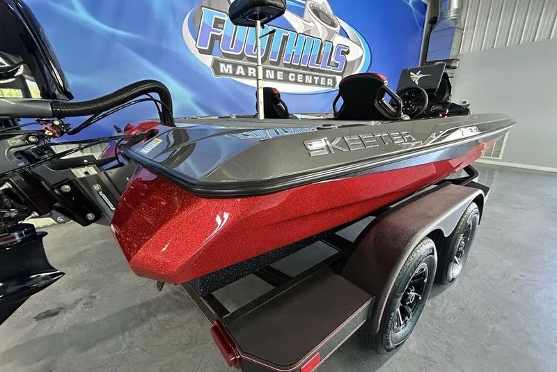 Slide: The Image of 2026 Skeeter ZXE20 boat in showroom, red and black design, on trailer. - 7