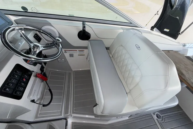 Slide: The Image of 2023 Regal 26 XO boat interior with steering wheel and cushioned seating. - 112