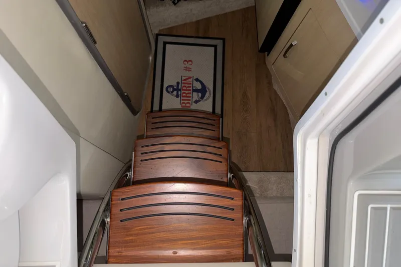 Slide: The Image of Interior stairs of 2023 Regal 26 XO boat with wooden steps and nautical-themed mat. - 118