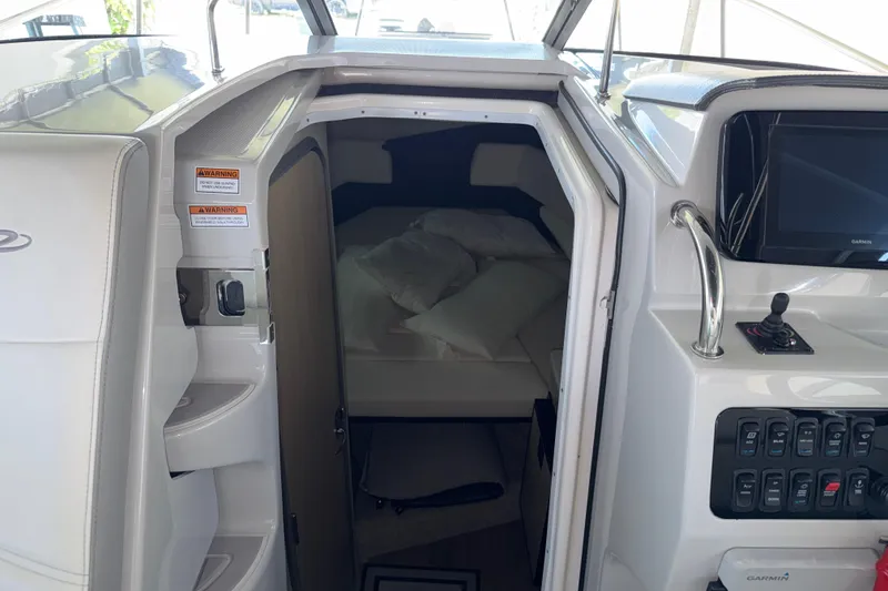 Slide: The Image of 2023 Regal 26 XO cabin interior with control panel and cozy sleeping area. - 120