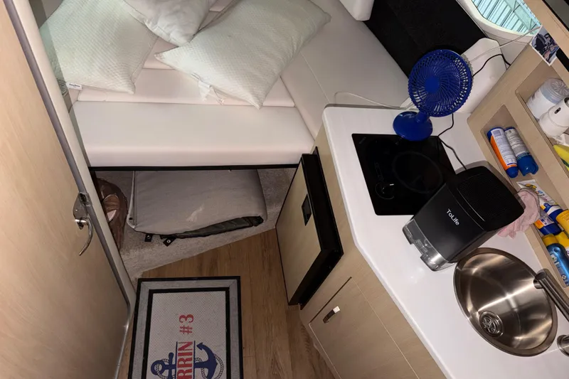 Slide: The Image of 2023 Regal 26 XO cabin interior with kitchenette, bed, and compact appliances. - 123