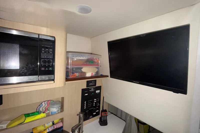 Slide: The Image of 2023 Regal 26 XO interior with microwave, TV, and storage shelves. - 126