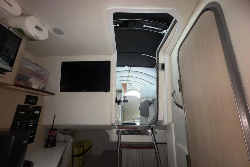 Slide: The Image of Interior view of 2023 Regal 26 XO boat cabin with TV and storage. - 133