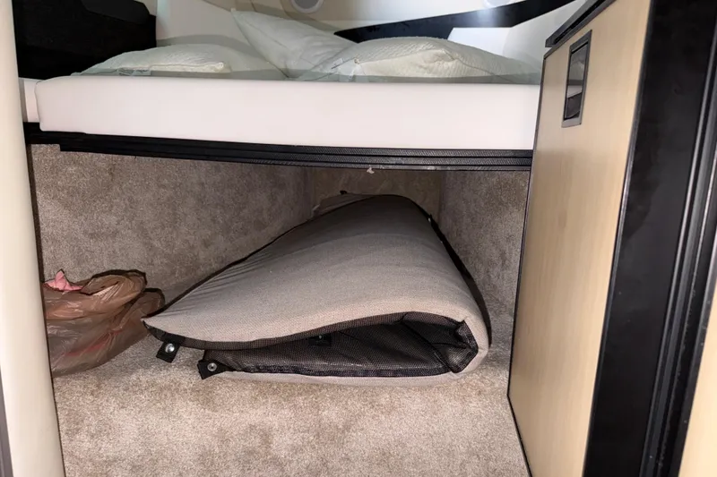 Slide: The Image of Interior storage space in 2023 Regal 26 XO boat, featuring carpeted flooring and a folded cushion. - 135