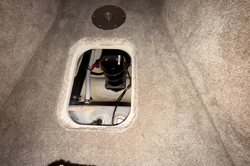 Slide: The Image of Carpeted interior compartment of 2023 Regal 26 XO boat showing mechanical components. - 142