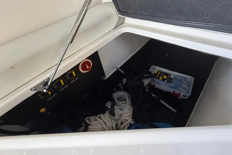 Slide: The Image of Storage compartment of 2023 Regal 26 XO boat with ropes and tools. - 145