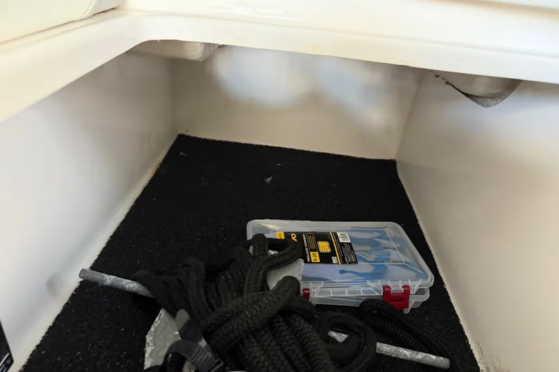 Slide: The Image of Storage compartment in a 2023 Regal 26 XO boat with tools and rope. - 146