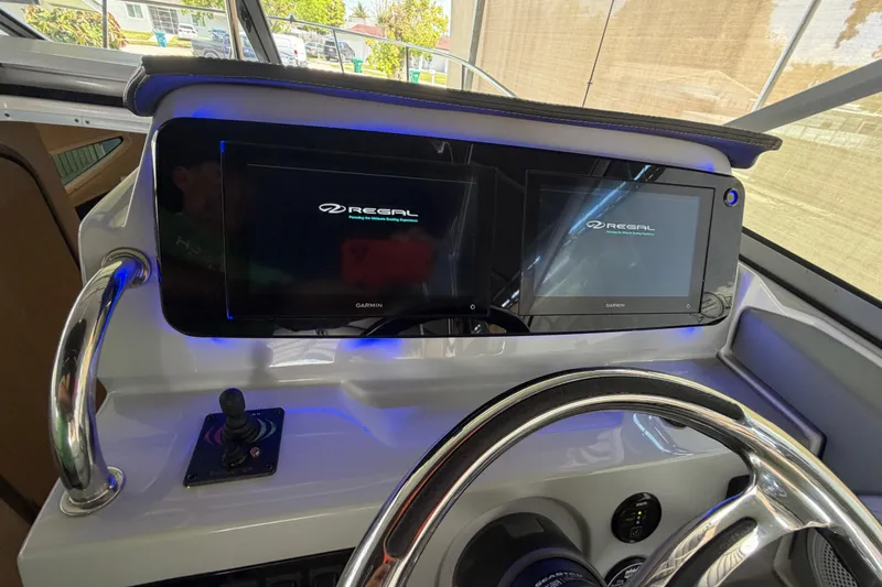 Slide: The Image of 2023 Regal 26 XO boat dashboard with dual Garmin displays and joystick control. - 148