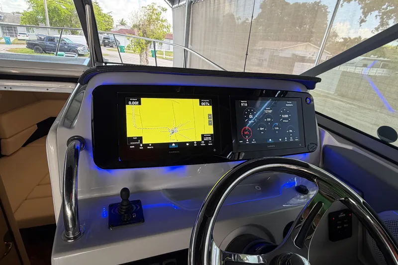 Slide: The Image of 2023 Regal 26 XO boat dashboard with dual Garmin displays and steering wheel. - 156