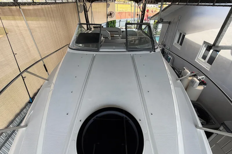 Slide: The Image of 2023 Regal 26 XO boat docked under shelter, showcasing sleek design and spacious deck. - 170