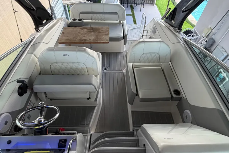 Slide: The Image of 2023 Regal 26 XO boat interior with plush seating and wooden table. - 176