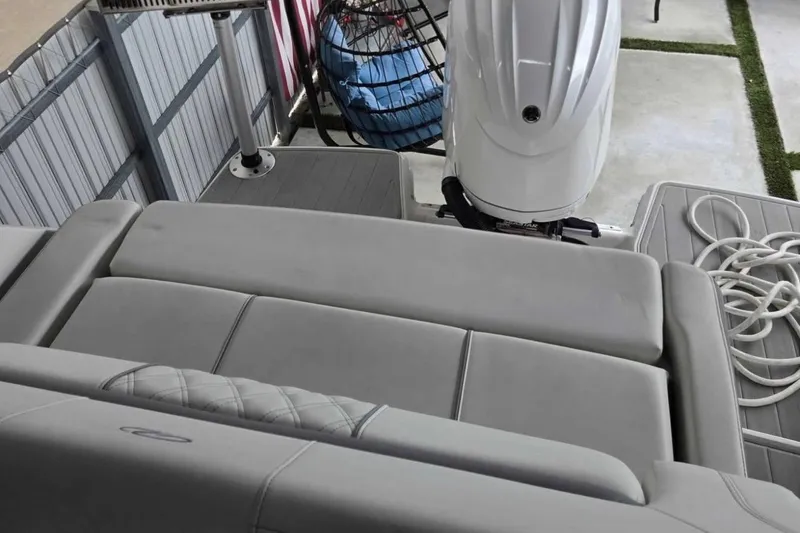 Slide: The Image of 2023 Regal 26 XO boat interior with cushioned seating and outboard motor. - 25
