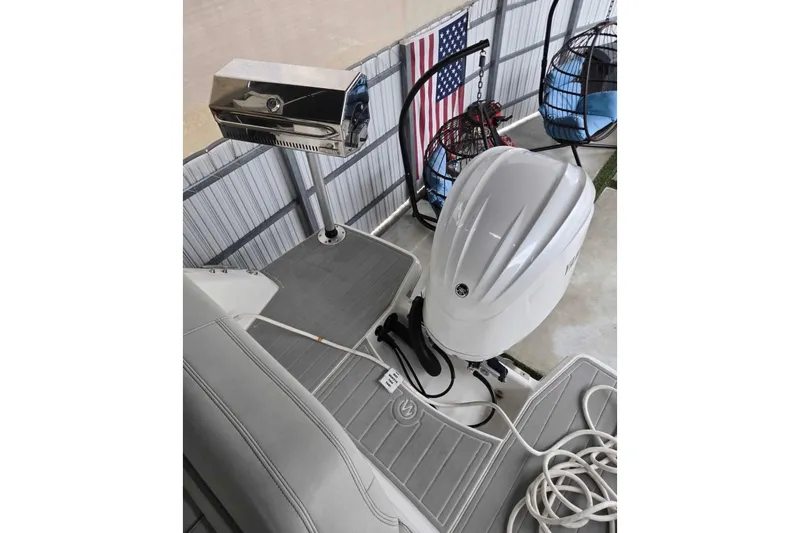 Slide: The Image of 2023 Regal 26 XO boat deck with outboard motor and grill setup. - 28
