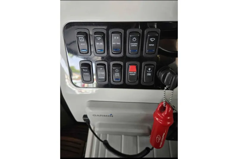 Slide: The Image of Control panel of 2023 Regal 26 XO boat with labeled switches and Garmin device. - 30