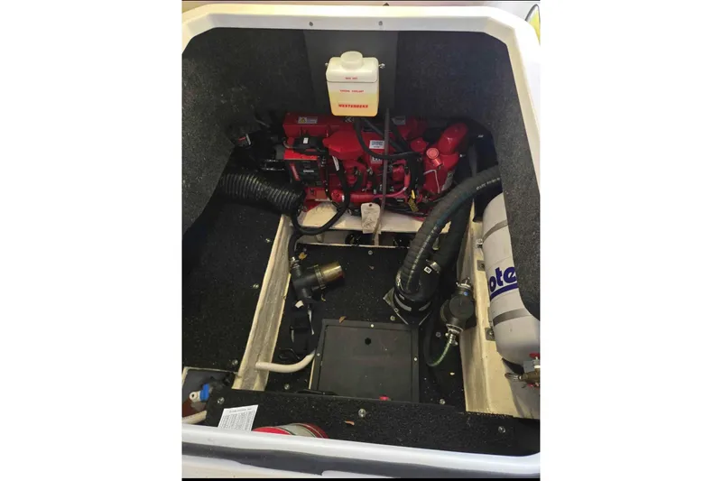 Slide: The Image of Engine compartment of 2023 Regal 26 XO boat, featuring mechanical components and hoses. - 32