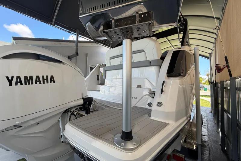 Slide: The Image of 2023 Regal 26 XO boat with Yamaha engine, docked under a canopy. - 52