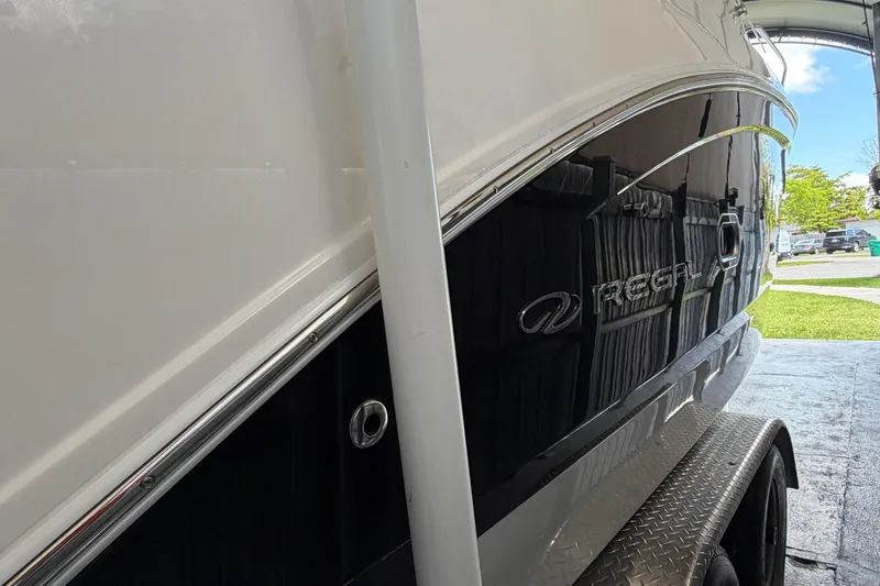 Slide: The Image of 2023 Regal 26 XO boat side view, showcasing sleek design and branding. - 57
