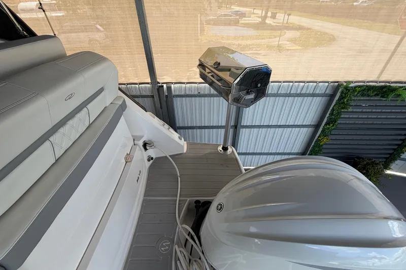 Slide: The Image of 2023 Regal 26 XO boat interior with seating and outboard motor in a covered area. - 59