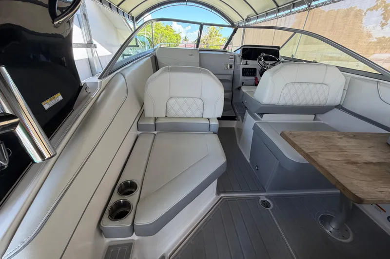 Slide: The Image of 2023 Regal 26 XO boat interior with white seating and wooden table. - 75
