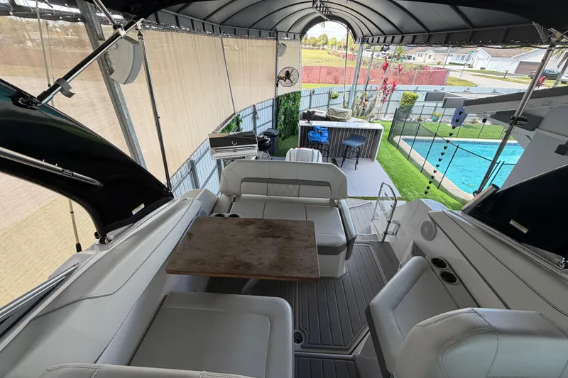 Slide: The Image of 2023 Regal 26 XO boat interior with seating, table, and poolside view. - 79