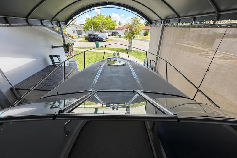 Slide: The Image of 2023 Regal 26 XO boat under a canopy in a residential driveway. - 80