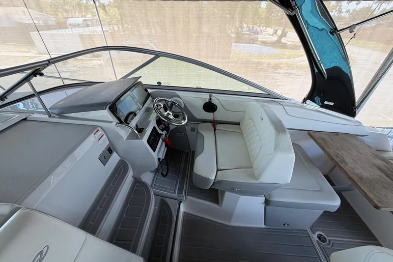 Slide: The Image of 2023 Regal 26 XO boat interior with helm, steering wheel, and seating area. - 82