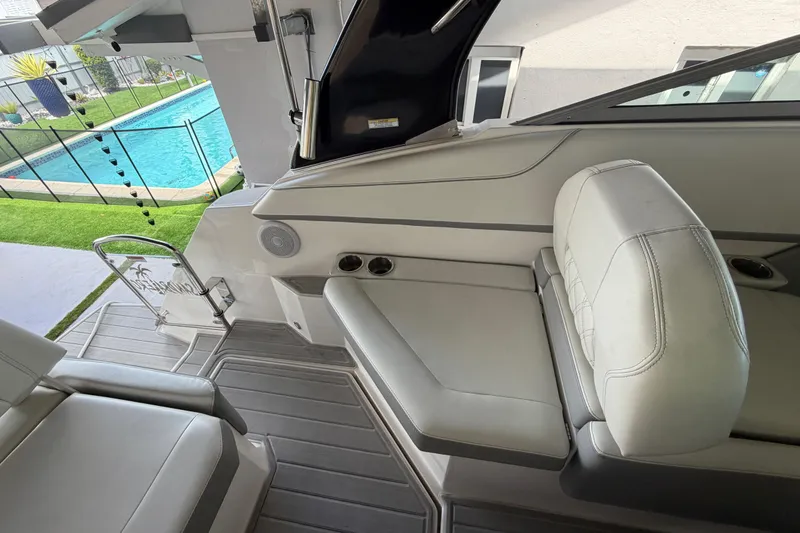 Slide: The Image of 2023 Regal 26 XO boat interior with white seating, near a pool. - 83