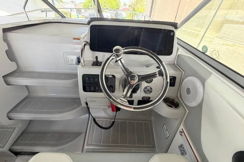 Slide: The Image of 2023 Regal 26 XO boat helm with modern steering wheel and control panel. - 85