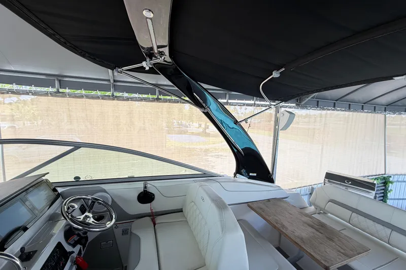 Slide: The Image of Interior of 2023 Regal 26 XO boat with steering wheel and seating area. - 87