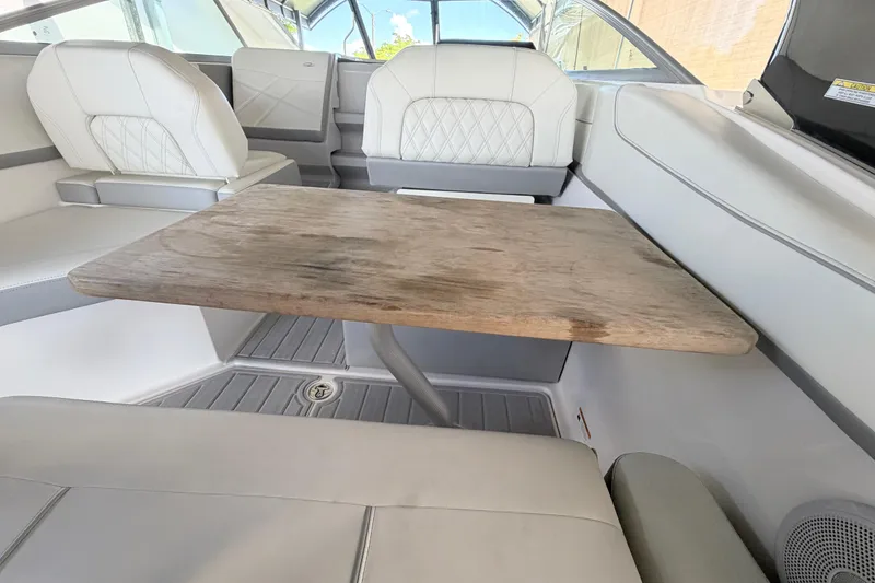 Slide: The Image of Interior of 2023 Regal 26 XO boat with wooden table and white seating. - 95
