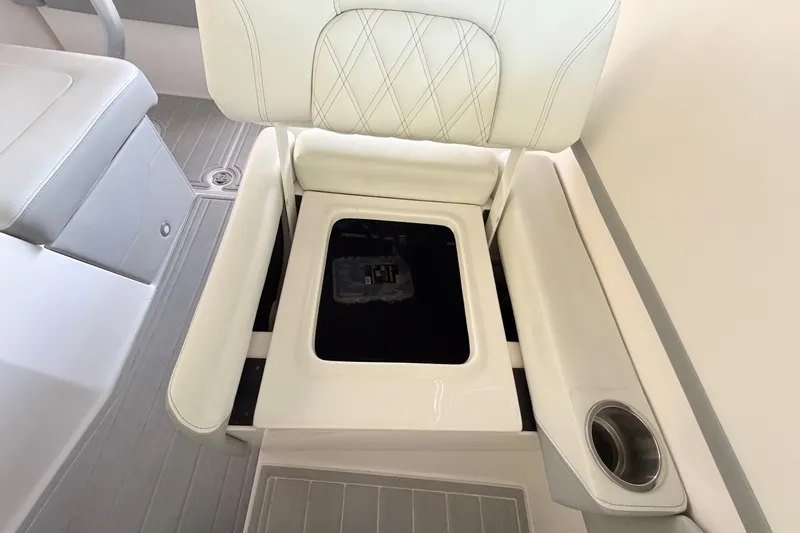 Slide: The Image of 2023 Regal 26 XO boat interior with white cushioned seating and storage compartment. - 97