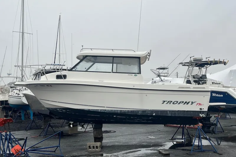 The Image of 2006 Trophy 2359 Hardtop boat on stands in a marina setting. - 1
