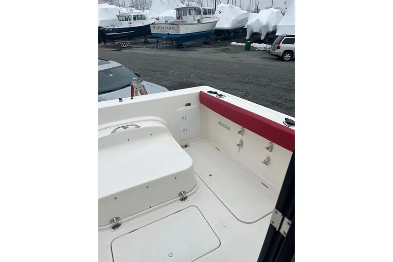 Slide: The Image of 2006 Trophy 2359 Hardtop boat interior with red trim, parked near other boats. - 10