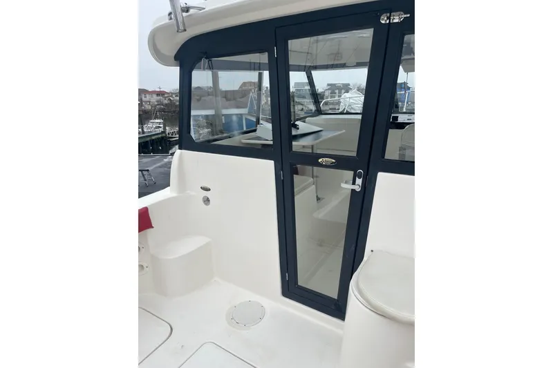 Slide: The Image of 2006 Trophy 2359 Hardtop boat with glass door and seating area. - 12