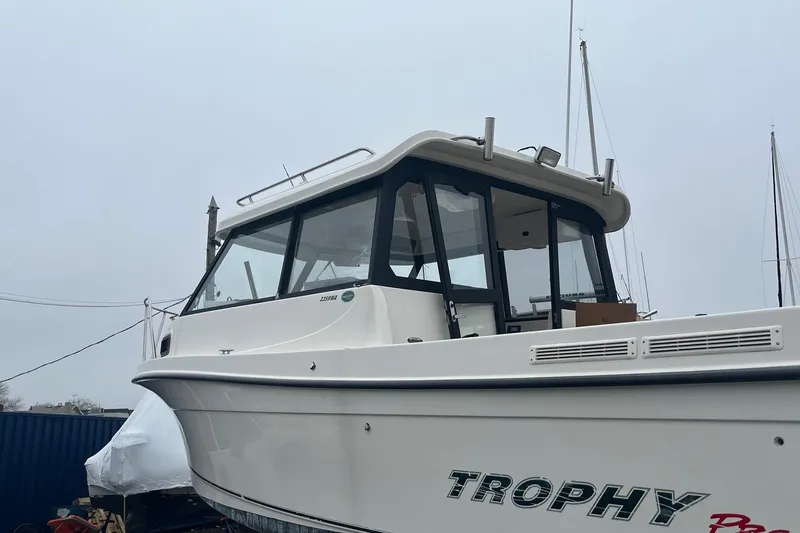 Slide: The Image of 2006 Trophy 2359 Hardtop boat with sleek design, docked on a cloudy day. - 16