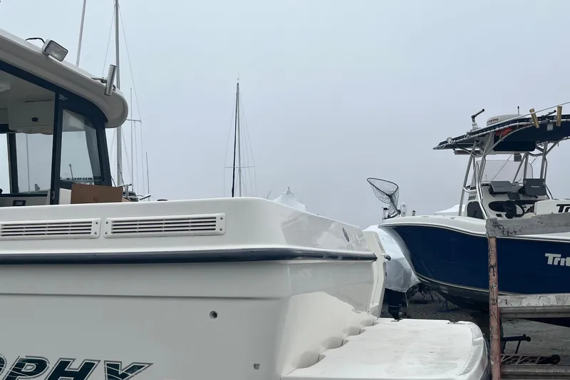 Slide: The Image of 2006 Trophy 2359 Hardtop boat docked alongside another vessel on a foggy day. - 17
