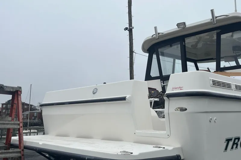 Slide: The Image of 2006 Trophy 2359 Hardtop boat docked, showcasing rear deck and cabin. - 21