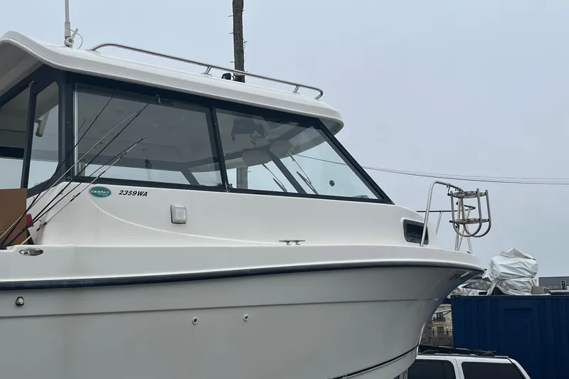 Slide: The Image of 2006 Trophy 2359 Hardtop boat with fishing rods, docked on a cloudy day. - 22