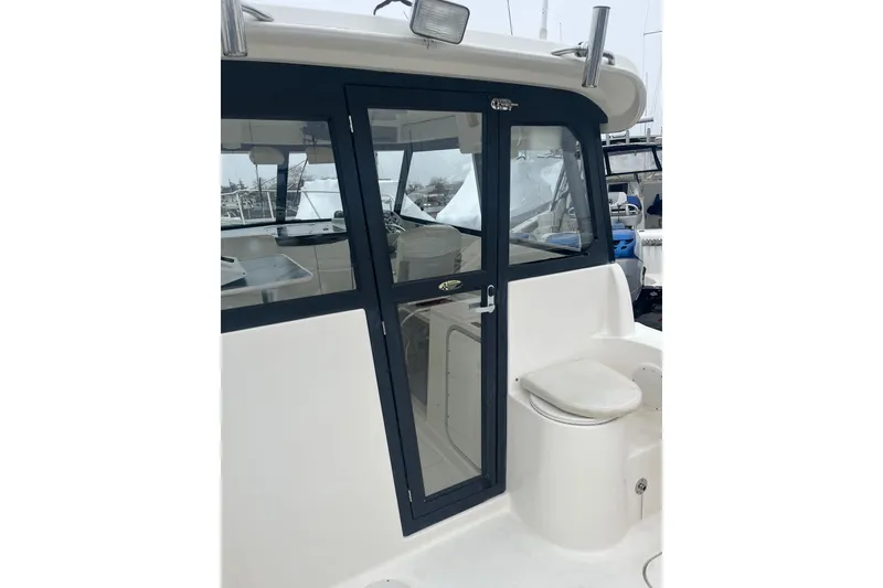 Slide: The Image of 2006 Trophy 2359 Hardtop boat with enclosed cabin and seating area. - 3