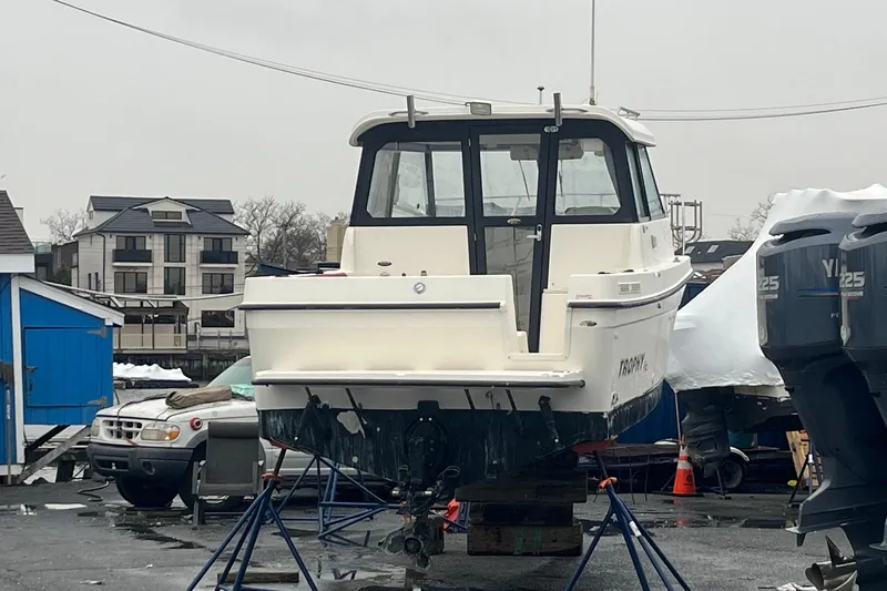 Slide: The Image of 2006 Trophy 2359 Hardtop boat on stands in a marina setting. - 30