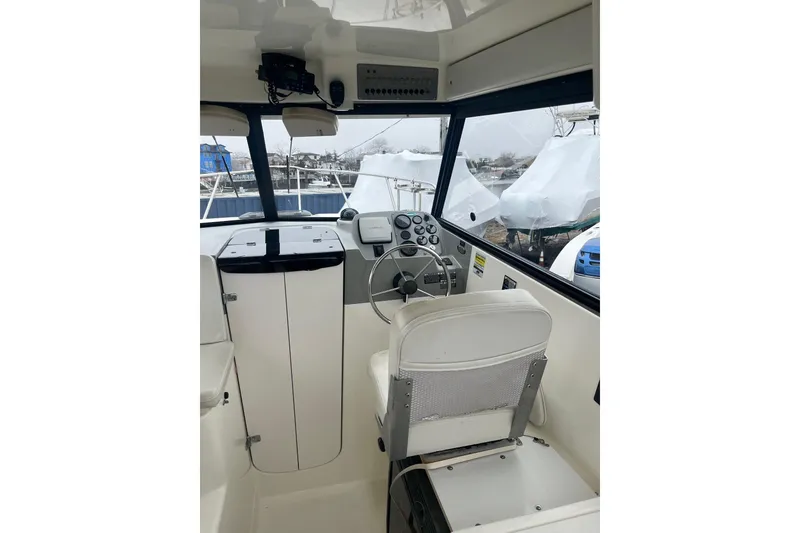 Slide: The Image of Interior of a 2006 Trophy 2359 Hardtop boat, featuring steering wheel and dashboard controls. - 4