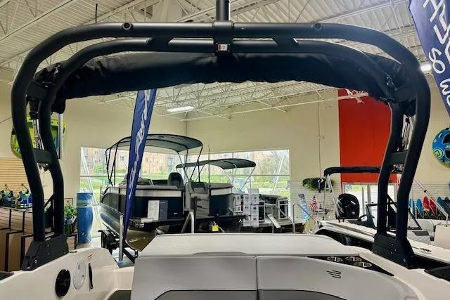Slide: The Image of 2026 Bayliner V20i boat interior with black canopy in showroom. - 8