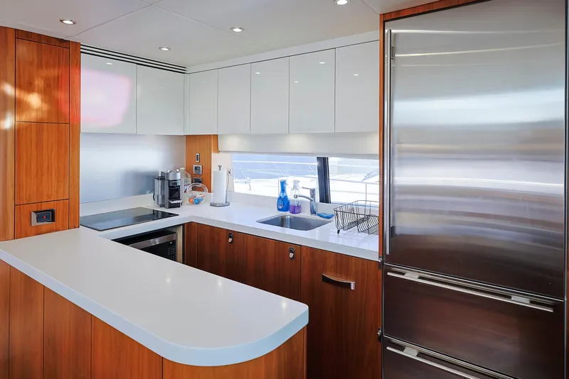 Slide: The Image of Modern kitchen interior on a 2015 Sunseeker 75 Yacht, featuring sleek cabinetry and stainless steel appliances. - 11