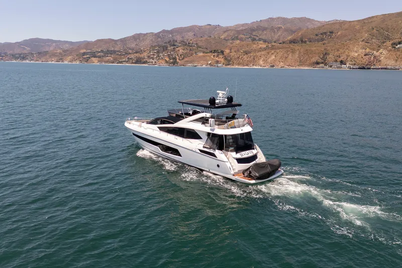 Slide: The Image of Luxurious 2015 Sunseeker 75 Yacht cruising on serene waters near scenic coastline. - 4