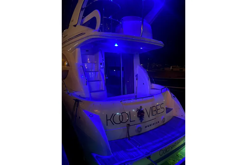 Slide: The Image of 2012 Meridian 341 Sedan yacht illuminated with blue lights at night, displaying "Kool Vibes." - 27