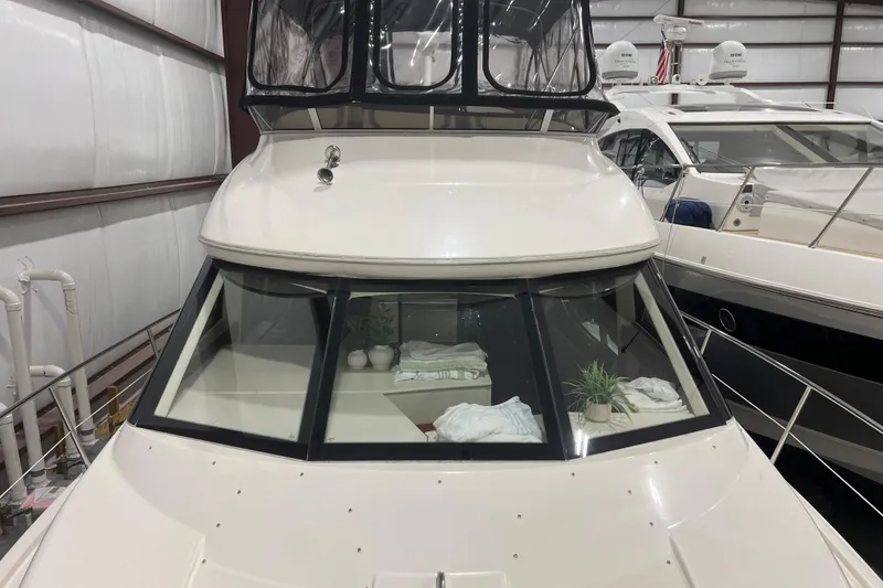Slide: The Image of 2012 Meridian 341 Sedan yacht in indoor storage, featuring sleek design and protective canopy. - 5